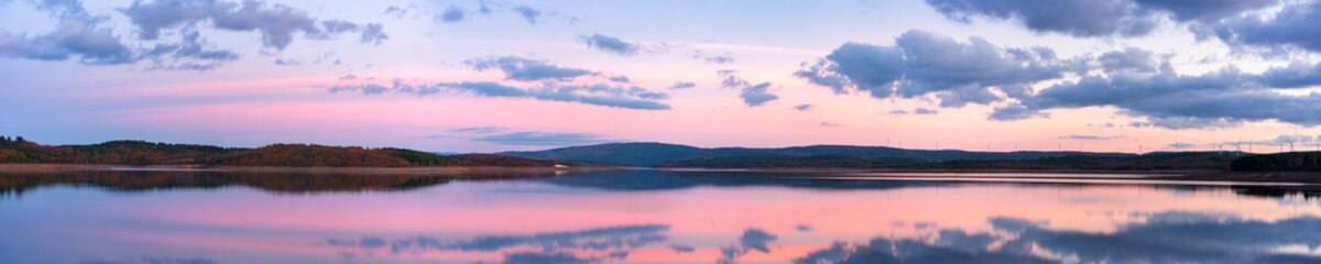 Fototapeta premium Panorama of a lake reservoir dam landscape view at sunset during autumn fall in Sabugal Dam, Portugal