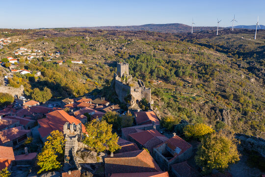 Drone aerial panorama of historic village of Sortelha with castle and with turbines on natural landscape, in Portugal