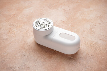 Modern fabric shaver, on a beige background.