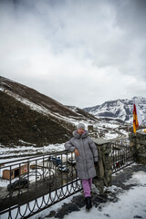Fototapeta na wymiar woman in gray jacket travels in the Caucasus mountains in winter