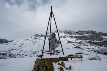 woman in pink suit and gray jacket posing in winter in the mountains 