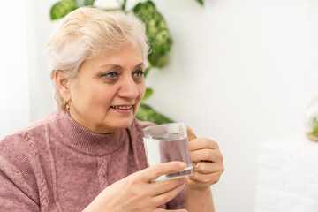 Senior woman drinking a glass of fresh water