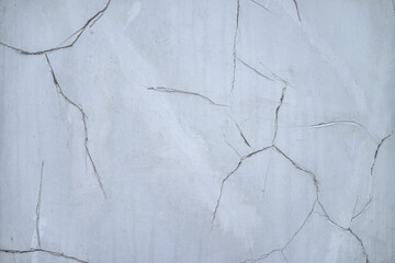 Fototapeta premium Cracks in the white plaster wall