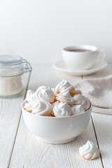 The white plate is filled with delicate, airy meringues on a light background.