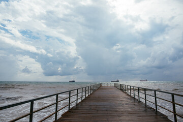 Obraz premium clouds over the sea. pier going into the distance