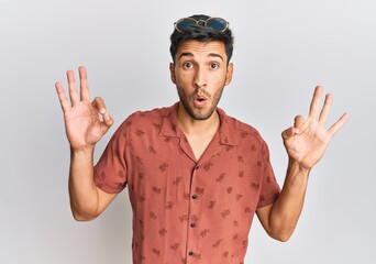 Young handsome man wearing casual summer clothes looking surprised and shocked doing ok approval...