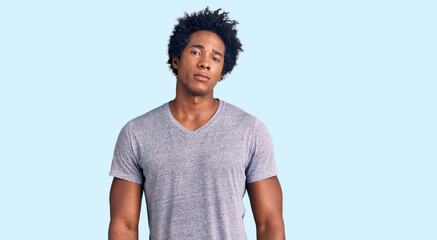 Handsome african american man with afro hair wearing casual clothes relaxed with serious expression on face. simple and natural looking at the camera.