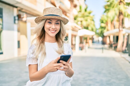 Young caucasian tourist girl smiling happy using smartphone at street of city.