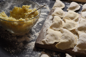 Dumplings with handmade potatoes on a black background. Shot from the top angle. Ukrainian folk cuisine.
