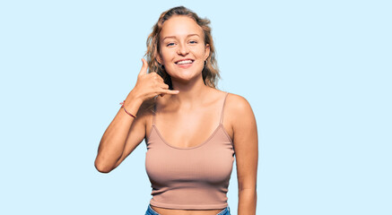 Beautiful caucasian woman wearing casual clothes smiling doing phone gesture with hand and fingers like talking on the telephone. communicating concepts.