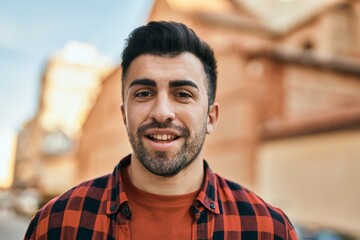 Fototapeta premium Young hispanic man smiling happy standing at the city.