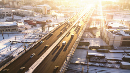 Top view of the freeway through cityscape at sunny sunset