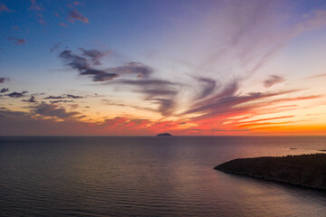Aerial drone shot of sunset burning sky clouds on Komiza town over Vis Island in Croatia Summer