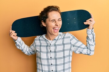Young brunette woman holding skate winking looking at the camera with sexy expression, cheerful and...