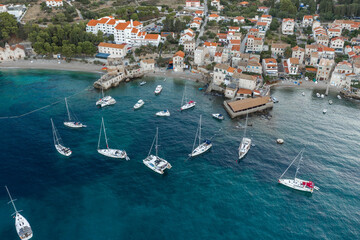 Aerial drone shot of yachts in Adriatic sea near Komiza town on Vis Island before sunrise hour in Croatia summer