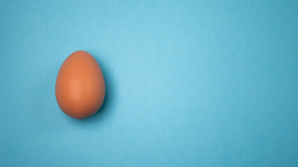 Decorated hand painted egg on blue background. Happy Easter concept composition. Image with copy free space for text message
