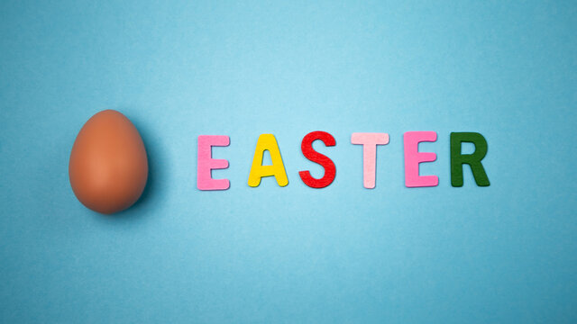 Decorated hand painted egg on blue background. Happy Easter concept composition. Image with copy free space for text message

