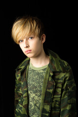 Confident teenage boy in camouflage clothin