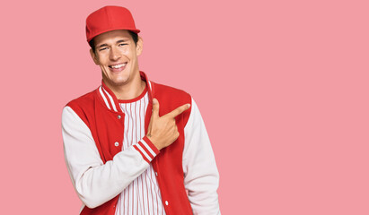 Handsome caucasian man wearing baseball uniform cheerful with a smile of face pointing with hand and finger up to the side with happy and natural expression on face