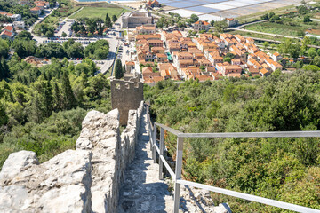 Narrow stone stair on Wall of Ston on hill with view of sault field in Croatia summer