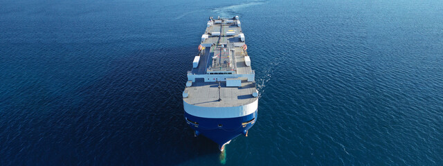 Aerial drone ultra wide photo of huge car carrier ship RO-RO (Roll on Roll off) cruising in Mediterranean deep blue Aegean sea