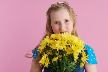 Portrait of relaxed stylish girl in dotted blue overall on pink