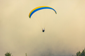 Paraglider in flight over Kitzbühel at Nebel, Austria.