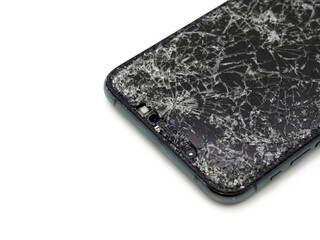 Modern midnight green smartphone with a broken glass display and damaged curved body close-up isolated on white background