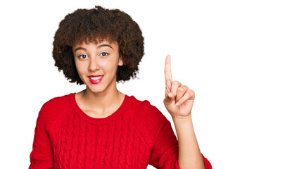 Young hispanic girl wearing casual clothes showing and pointing up with finger number one while smiling confident and happy.