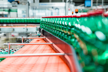 Bottling plant - Water bottling line for processing and bottling carbonated water into green bottles. Selective focus.