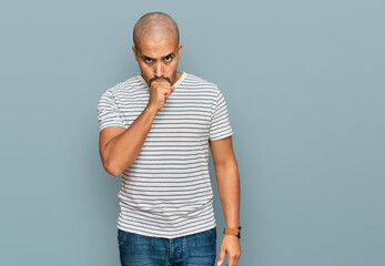 Hispanic adult man wearing casual clothes feeling unwell and coughing as symptom for cold or...