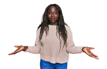 Young african woman wearing wool winter sweater clueless and confused with open arms, no idea concept.