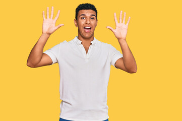 Fototapeta premium Young arab man wearing casual clothes showing and pointing up with fingers number ten while smiling confident and happy.