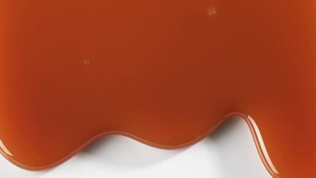 close up of flowing melted caramel sauce macro on white background