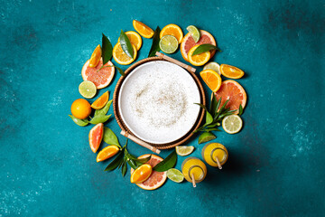 Citrus slices - orange,lemon and grapefruit with green leaves and citrus juice around empty plate...