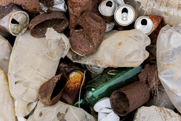 pile of polluting garbage in the field, with plastic and glass bottles, cans and metal cans.
