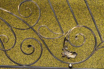 Decorative wrought iron zabo on a background of a yellow wall with a Venetian