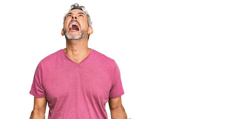 Middle age grey-haired man wearing casual clothes angry and mad screaming frustrated and furious,...