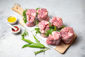 Pork Osso Buco, shin Pork shanks with fresh aromatic herbs on white marmol board