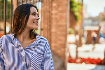 Young hispanic girl smiling happy standing at the city.