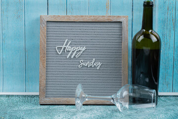 Happy sunday poster embedded on grey background with a bottle of wine