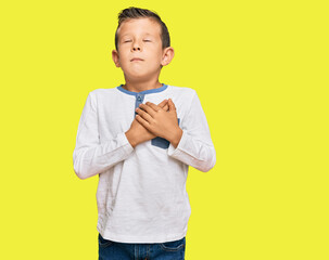 Adorable caucasian kid wearing casual clothes smiling with hands on chest with closed eyes and grateful gesture on face. health concept.