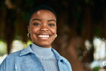 Young african american woman smiling happy standing at the park.