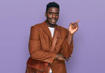 Handsome business black man wearing leather bag smiling happy pointing with hand and finger to the side