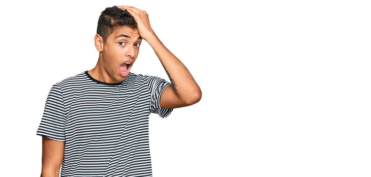 Young handsome african american man wearing casual clothes surprised with hand on head for mistake, remember error. forgot, bad memory concept.
