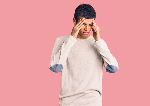 Young african amercian man wearing casual clothes with hand on head for pain in head because stress. suffering migraine.