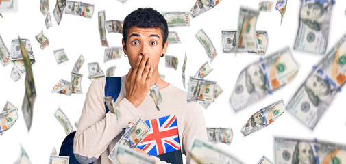 Young african amercian man wearing student backpack holding binder and uk flag covering mouth with hand, shocked and afraid for mistake. surprised expression