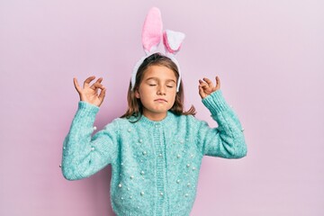 Little beautiful girl wearing cute easter bunny ears relax and smiling with eyes closed doing...