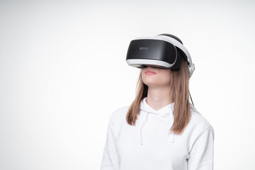 Profile portrait of a teenage girl in VR glasses, studio, white background
