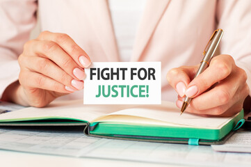 A card in the hand of a woman with the inscription FIGHT FOR JUSTICE